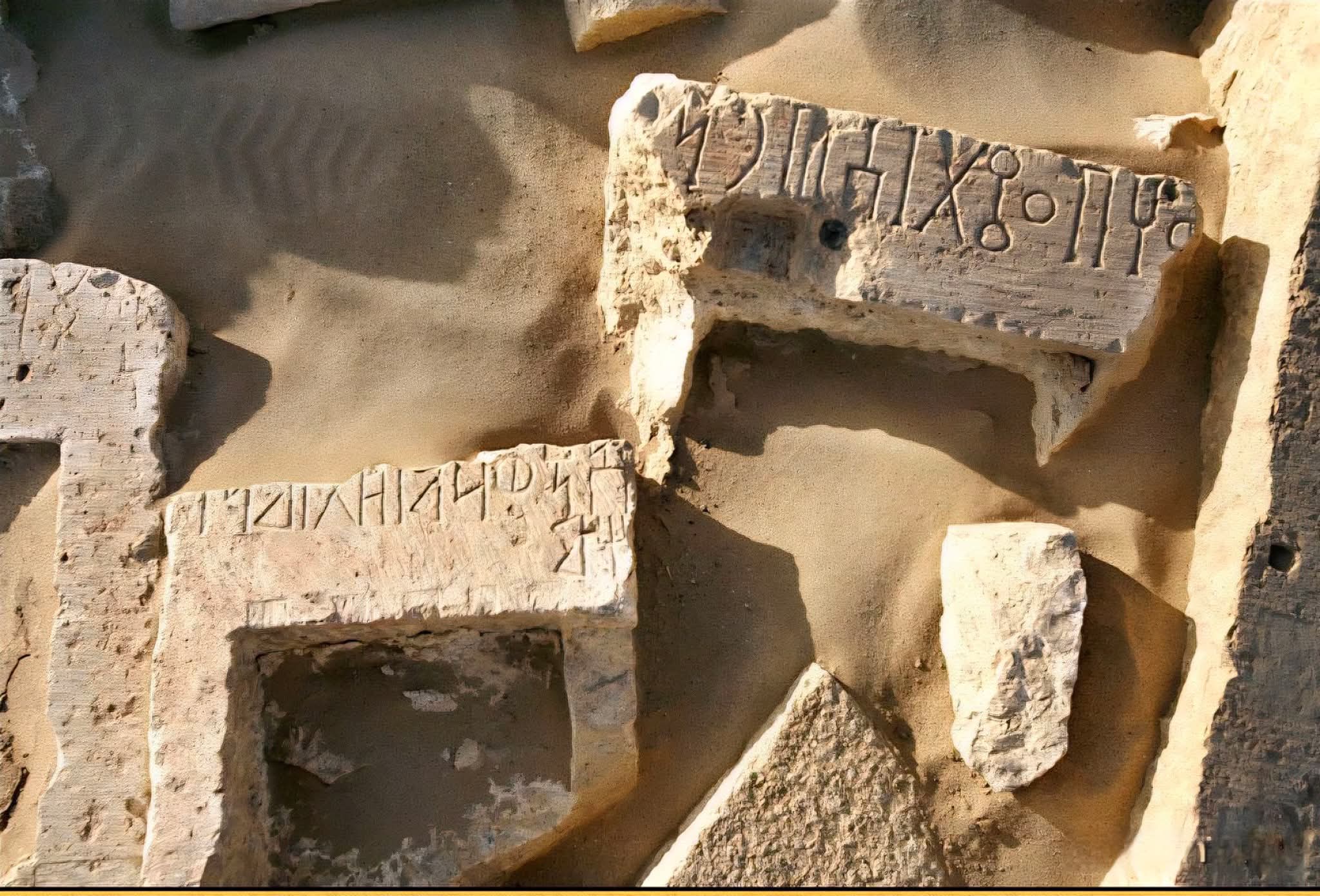 صورة لمصور روسي لنقوش مسندية متناثرة على الرمال.